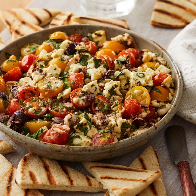 Baked Feta with Chopped Olives, Herbs, and NatureSweet® SunBursts® and Glorys® Tomatoes Served with Pita Chips